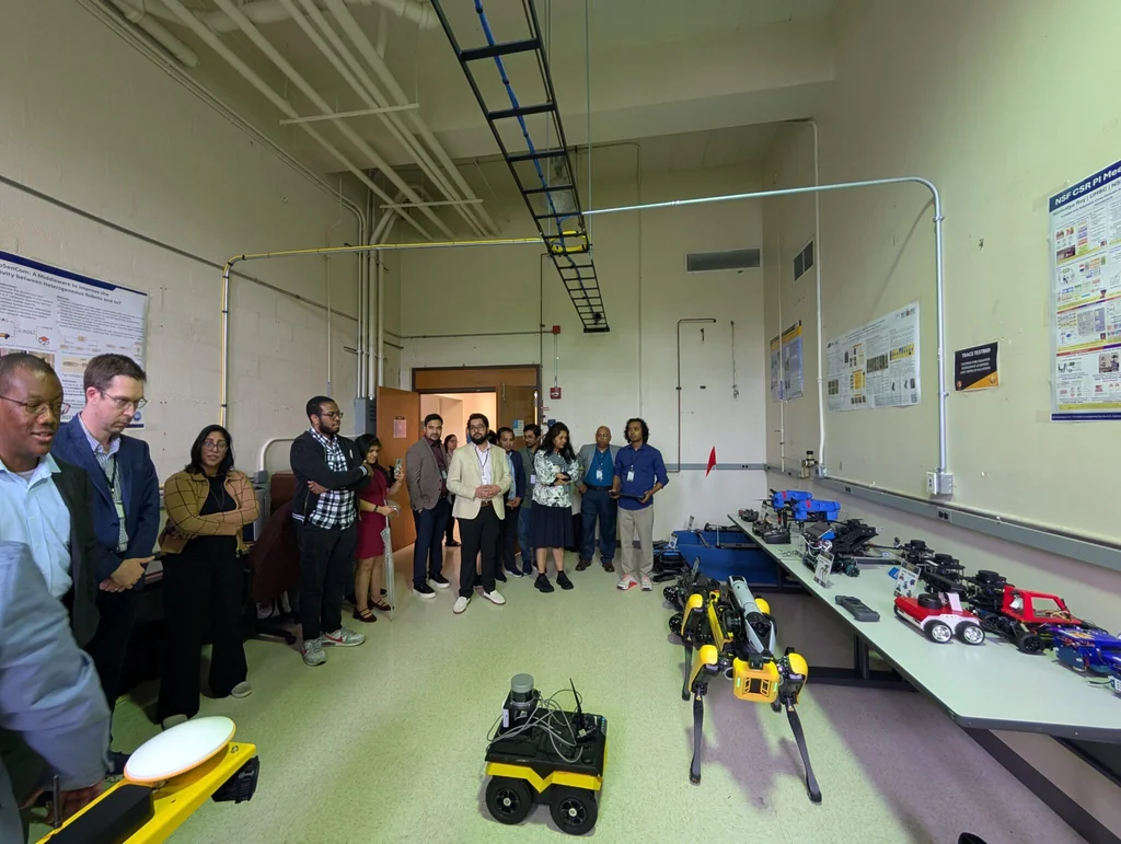Participants observing mobile and quadruped robots inside the CYPRESS research lab