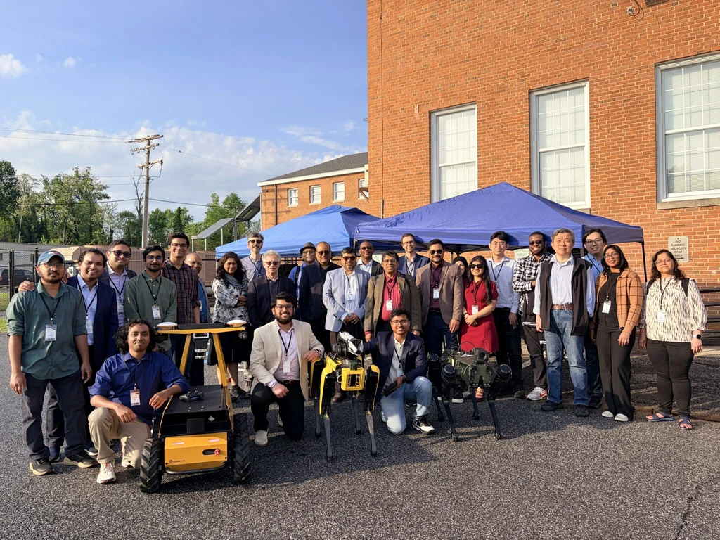 Field demonstration participants posing together with robots at the CYPRESS Technology Research Center