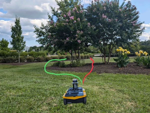 Outdoor robot navigation scene with two alternative routes marked around vegetation